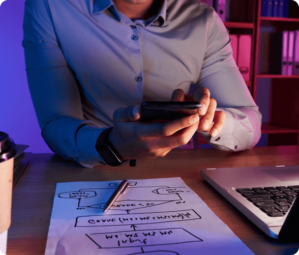 A man at a desk, engaged in tasks, surrounded by documents and a laptop, showcasing a professional environment.