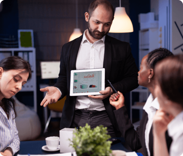 A man delivers a presentation to a captivated audience, illustrating key points with visual materials in a conference room.