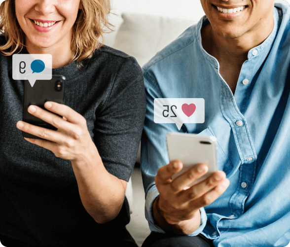 Two friends on a couch, each absorbed in their smartphones while enjoying each other's company.