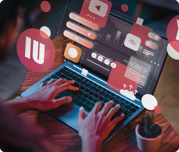 A person engaged with a laptop displaying various icons on the screen, focused on their work.