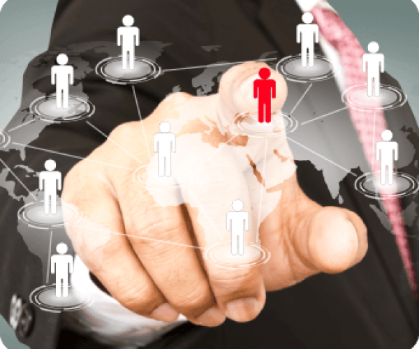 A suited individual gestures towards a gathering of people, indicating a point of interest or discussion.